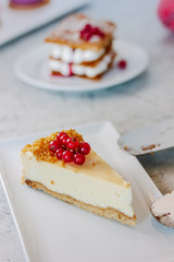 Poster - Cheesecake with red currant berries on white plate.