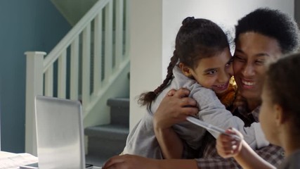 pan of happy black primary age girl with plush toy running down stairs and hugging her cheerful moth