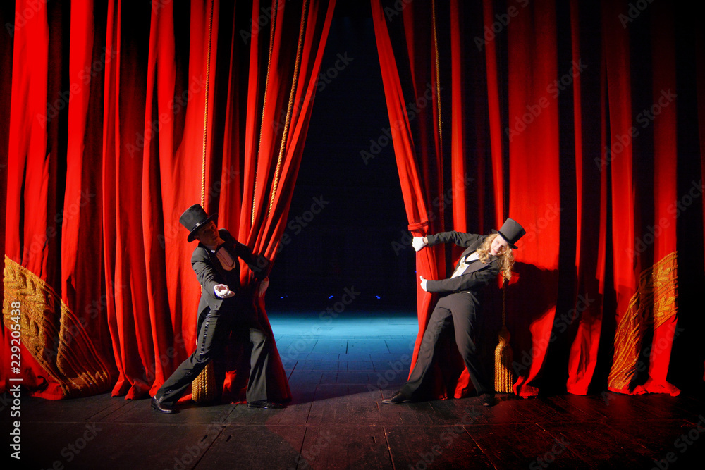 Actors in tuxedos and hats look behind the theater curtain - obrazy, fototapety, plakaty 
