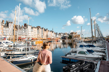 Wall Mural - Young woman tourist enjoying beautiful view on the harbour traveling in Honfleur town in Normandy, France