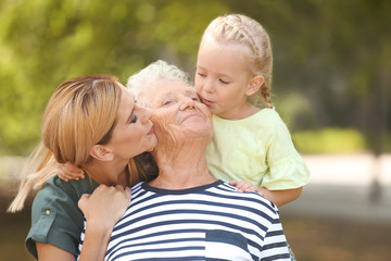 Poster - Woman with daughter and elderly mother outdoors