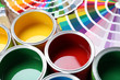 © New Africa - Paint cans and color palette samples on table, closeup