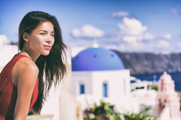 Fototapete - Luxury Europe cruise travel vacation Santorini woman looking at view. Tourist Asian girl relaxing at three blue domes, Oia, Greece, european destination.