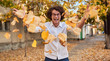 © iuricazac - Horizontal autumn shot of happy handsome winner young man with glasses playing with leaves outdoors.Successful male student enjoy triumph.Smart guy in white shirt, spectacles with curly hair on street
