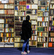© bibiphoto - A woman looks at large book shelf