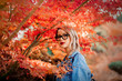 © Masson - Young redhead girl in glasses and blue jeans jacket in a park. Autumn season time