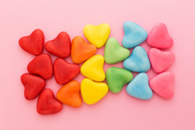 Multi-colored Heart-shaped Candy Arranged In Rainbow Colors, On A Pink Background