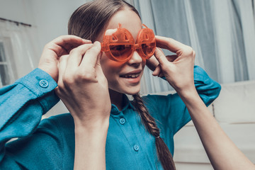 Woman putting Pumpkin Glasses on Little Girl