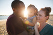 © Rob and Julia Campbell/Stocksy - Young happy family of three enjoying vaction life on the beach t