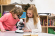 © Sean Locke Photography/Stocksy - Classroom girls use microscope to examine blood