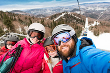 Family on ski lift on Quebec ski vacation takes a selfie