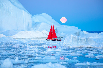 Wall Mural - little red sailboat cruising among floating icebergs in disko bay glacier during midnight sun season
