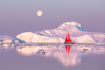 Wall Mural - little red sailboat cruising among floating icebergs in disko bay glacier during midnight sun season