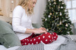 © Alexandr Ivanets/Stocksy - Woman typing on laptop at Christmas tree