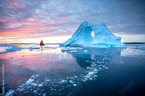 mala-czerwona-zaglowka-plywajaca-wsrod-plywajacych-gor-lodowych-w-lodowcu-disko-bay-podczas-polnocnego-sezonu-letniego-polarnego-ilulissat-grenlandia