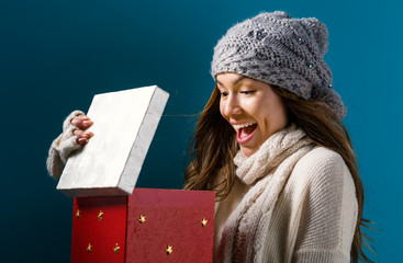 Wall Mural - Happy young woman opening a Christmas present box