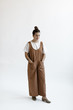 © Nicole Mason/Stocksy - young woman wearing a modern stylish jumpsuit