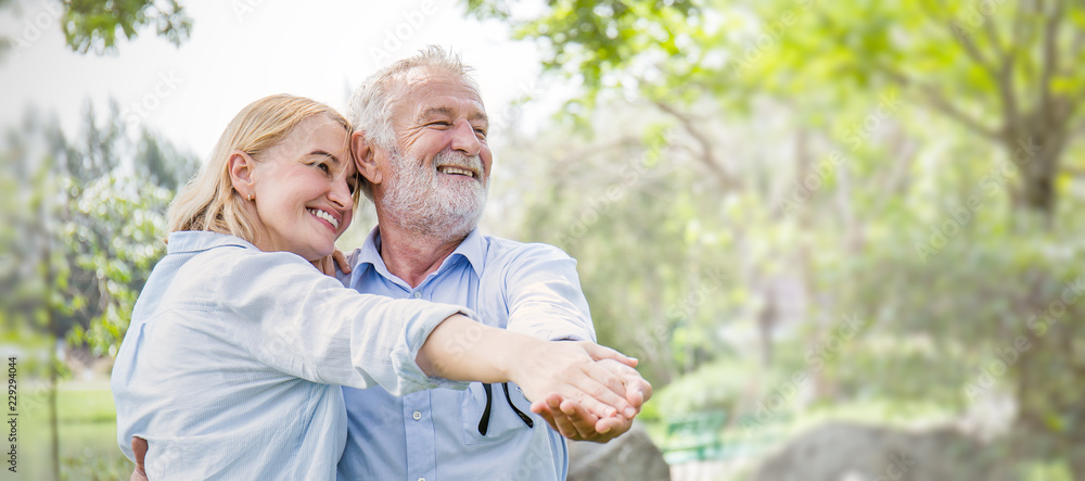 Happy old couple smiling dancing in a park on a sunny day, hoot senior couple relax in the forest spring summer time. Healthcare lifestyle retirement concept banner - obrazy, fototapety, plakaty 