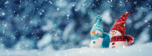Little Knitted Snowmans On Soft Snow On Blue Background