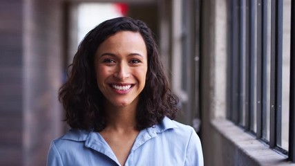 Wall Mural - Young mixed race businesswoman turning to camera, smiling