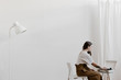 © Nicole Mason/Stocksy - stylish young woman putting a record on in a minimal white interior