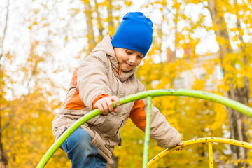 Poster - boy playing on the Playground in autumn