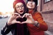 © opolja - Outdoors fashion portrait young pretty best girls friends in friendly hug. Walking at the city. Posing at the street. Wearing stylish outerwear and hats. Bright make up. Positive emotions.