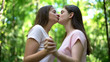 © motortion - Pretty lesbians holding hands and kissing, support despite society condemnation