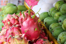 Colourful Display Of Pink Dragonfruit Also Called Pitaya, Green Mangoes And Papayas On A Fruit Stand In Indonesia