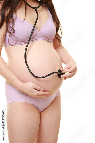 お腹に聴診器をあてて胎児の心音を聴く薄紫色の下着を着た臨月の妊婦 Stock Photo Adobe Stock お腹に聴診器をあてて胎児の心音を聴く薄紫色の下着を着た臨月の妊婦 Stock Photo Adobe Stock