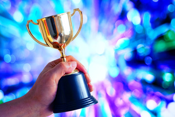 Wall Mural - winner hold trophy with abstract light glowing background