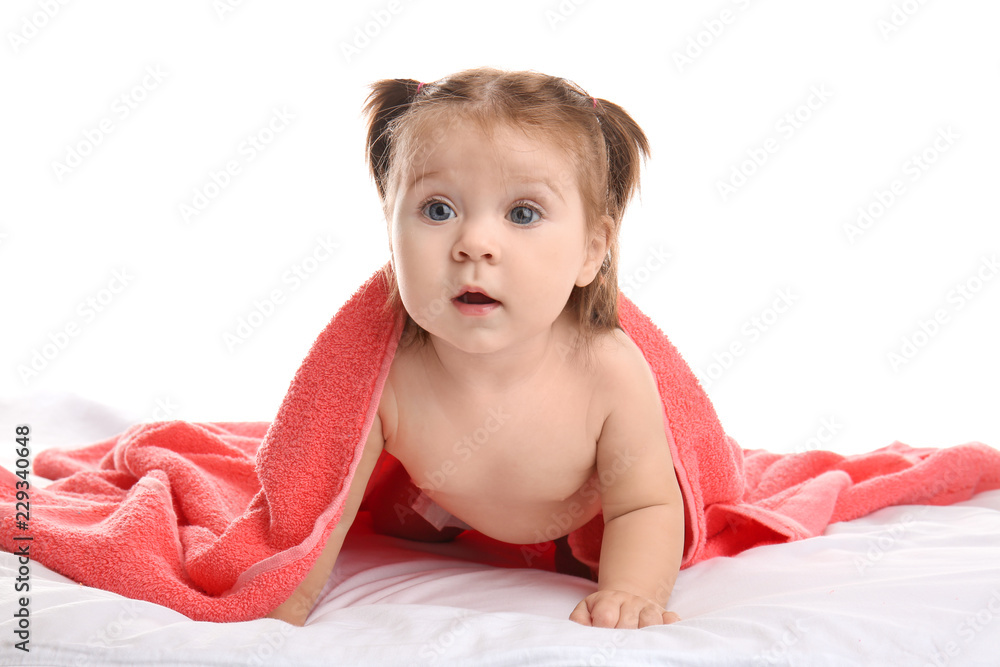 Cute little baby with soft towel on bed against white background