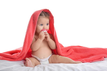 Cute little baby with soft towel on bed against white background