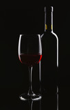 Fototapeta Panele - Bottle and glass of red wine on dark background
