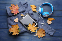 Composition With Tablet PC, Headphones And Autumn Leaves On Color Wooden Background