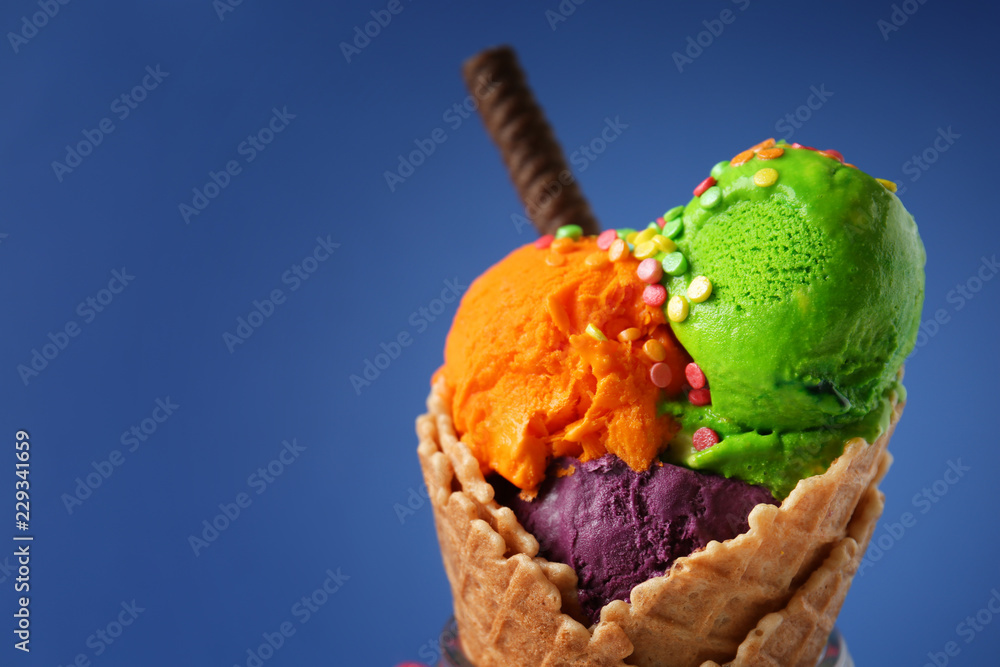 Waffle cone with delicious ice cream on color background, closeup