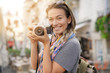 © goodluz - Attractive young woman taking photographs on SLR