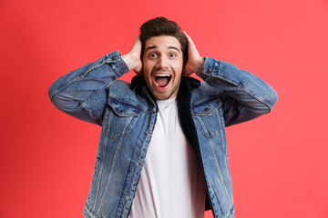 Wall Mural - Portrait of an excited young man dressed in denim jacket