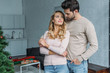 © LIGHTFIELD STUDIOS - handsome boyfriend hugging attractive girlfriend at home, christmas concept