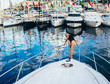 Young beautiful girl staying on front on yacht