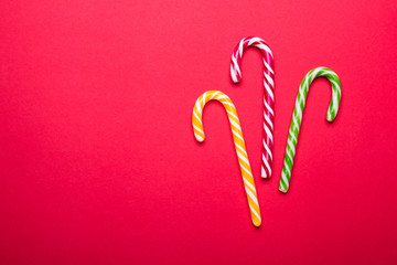 Wall Mural - Three Christmas candy canes on red background