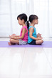 Leinwandbild Motiv Asian Chinese little sisters practicing yoga pose on a mat