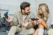 © LIGHTFIELD STUDIOS - happy young couple playing video games together on couch at home