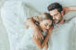 © LIGHTFIELD STUDIOS - top view of beautiful young couple sleeping together and hugging in bed at home