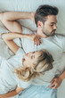 © LIGHTFIELD STUDIOS - top view of beautiful young couple sleeping together in bed at home