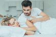 © LIGHTFIELD STUDIOS - beautiful young couple cuddling in bed at home in morning