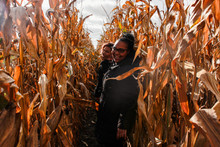 Two Young Woman Walking Through A Corn Field