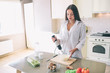 © estradaanton - Intimate picture of beautiful girl stands in kitchen and cooking. She is mixing together milk and eggs. There is a white bra underneath her shirt.