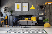 Lemons In Metal Basket On Wooden Coffee Table In Grey Scandinavian Living Room With Industrial Furniture And Patterned Carpet, Real Photo