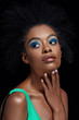 © LIGHTFIELD STUDIOS - portrait of pensive african american model with bright blue eyes shadows isolated on black